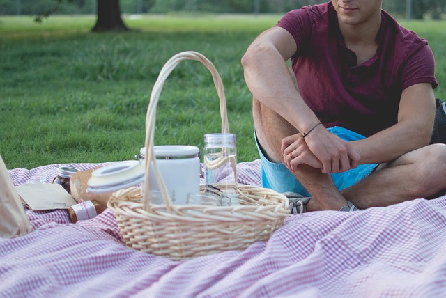 A guy sitting on a picnic blanket